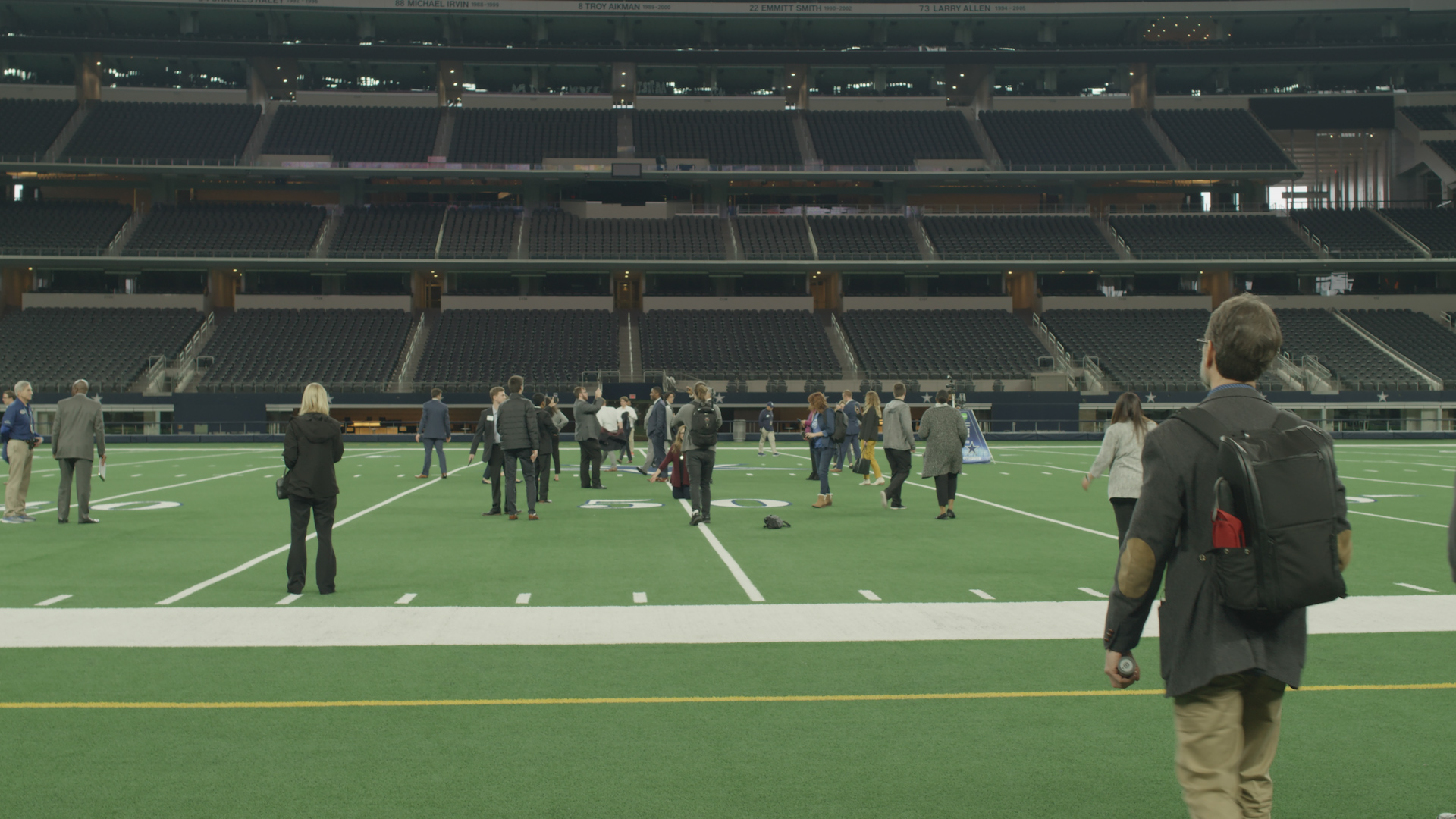 Picture of students walking on the field at AT&T stadium