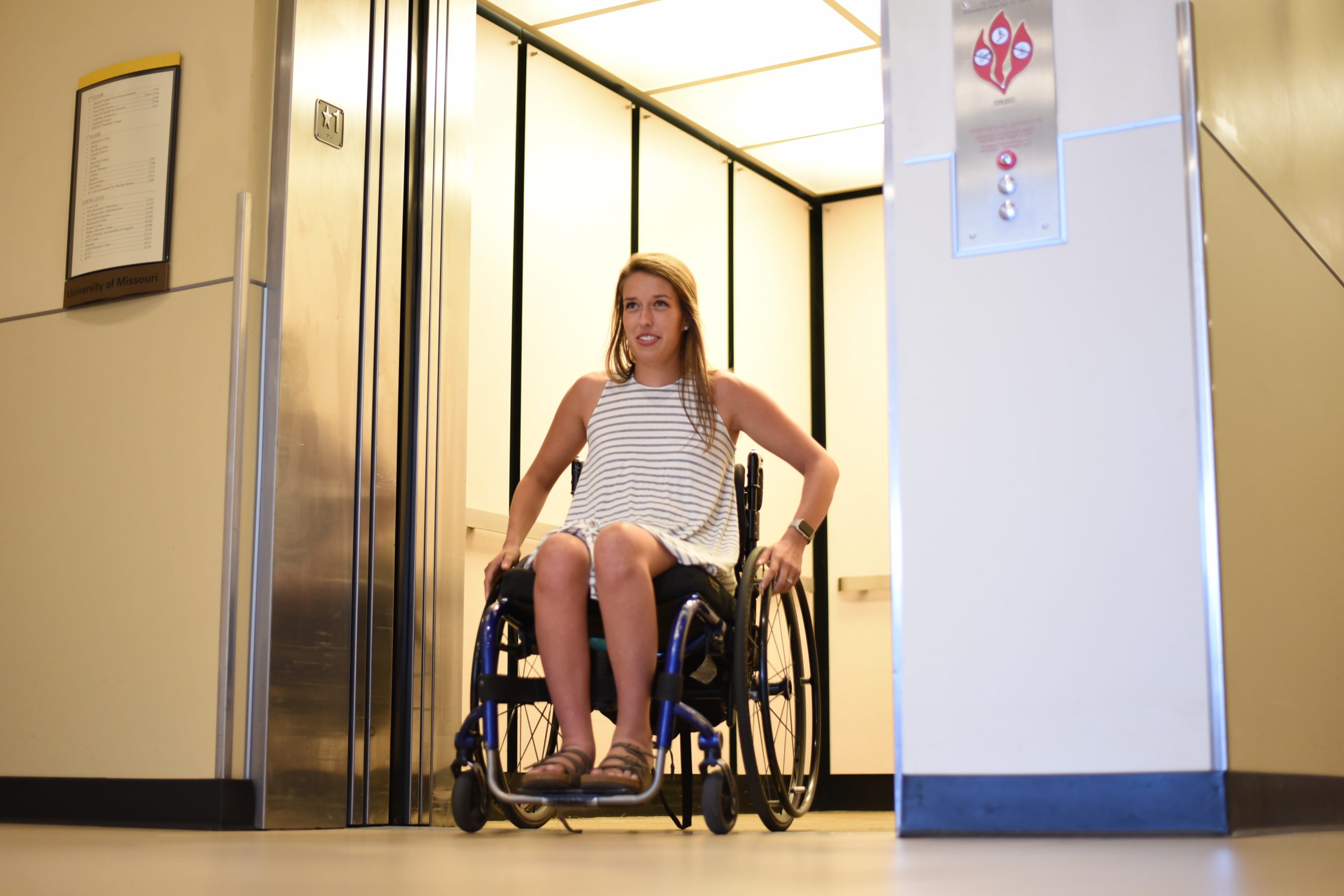 This is a picture of a student in a wheelchair exiting an elevator.
