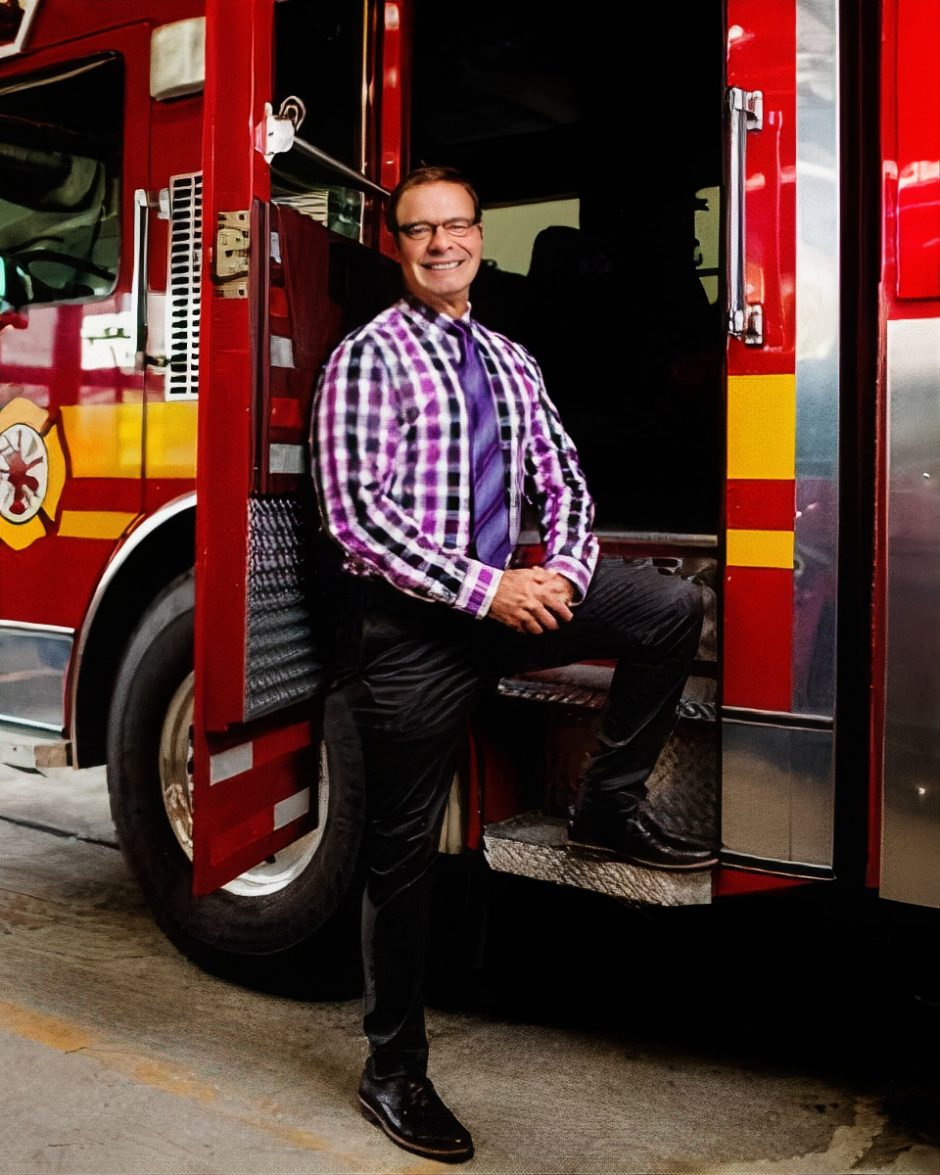 Greg Lind stands in front of fire engine.