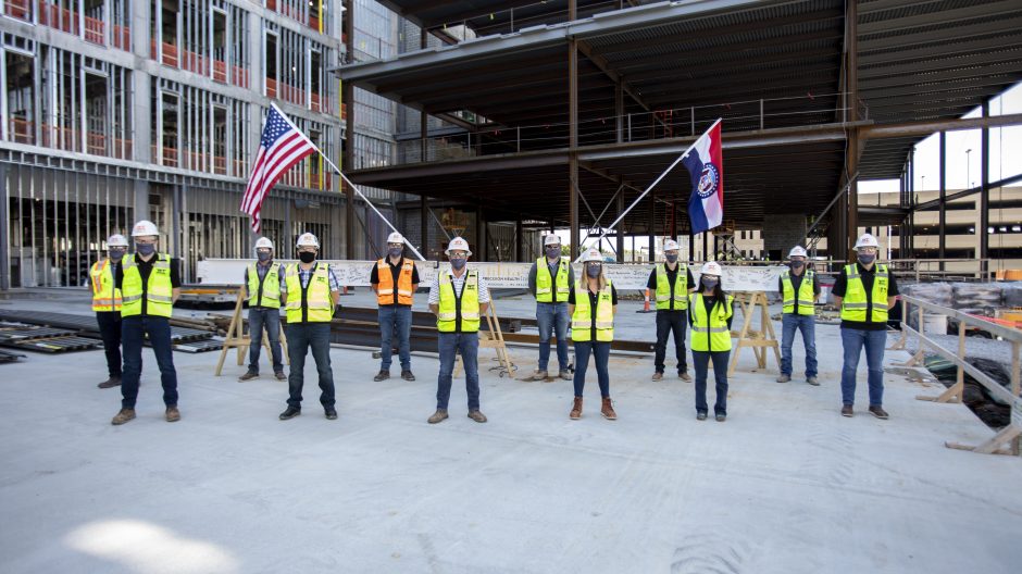 The construction team placed the U.S. and Missouri state flags on the final steel beam of the NextGen Precision Health Institute.
