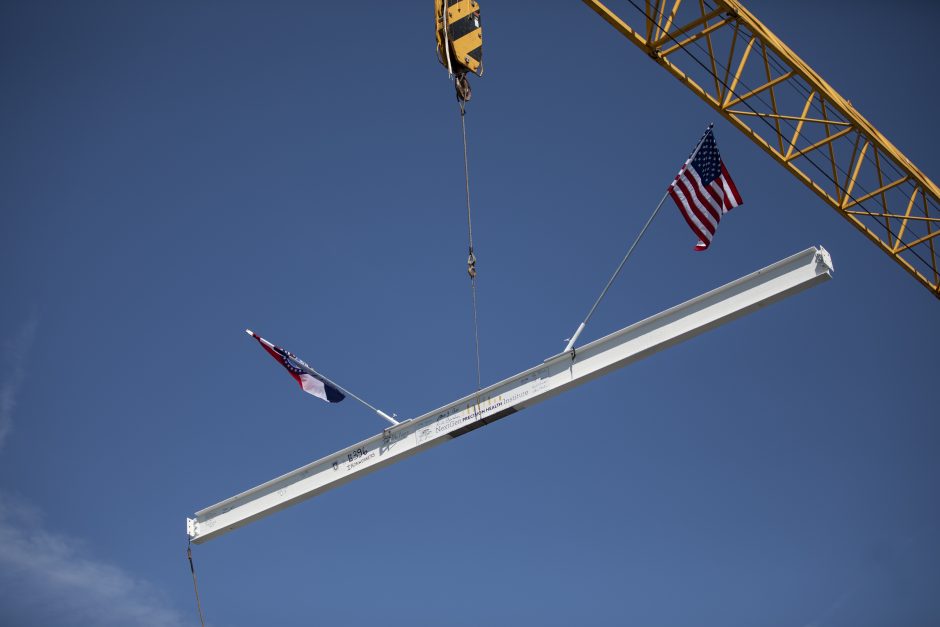 A crane lifts the final steel beam of the NextGen Precision Health Institute. The beam was installed on the top of the building during a virtual topping off ceremony on June 18, 2020.