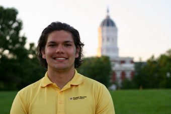 student standing in front of jesse hall in yellow shirt